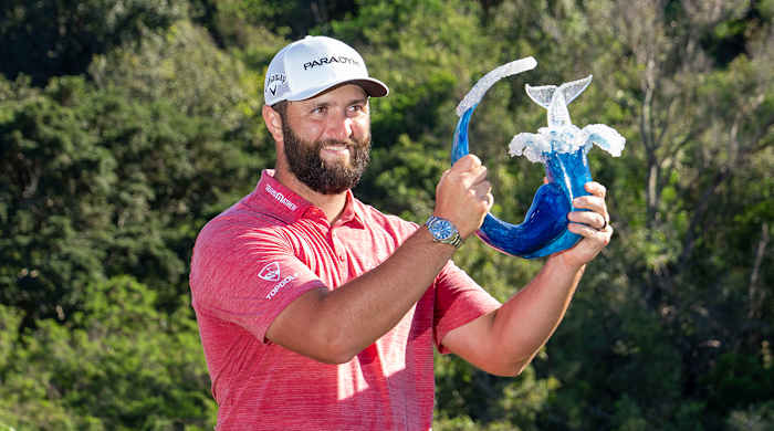Jon Rahm hoists the trophy on the 18th hole during the final round of the Sentry Tournament of Champions golf tournament at Kapalua Resort - The Plantation Course.